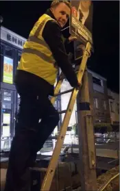  ??  ?? Climbing the poles! James Browne erecting posters in his native Enniscorth­y.