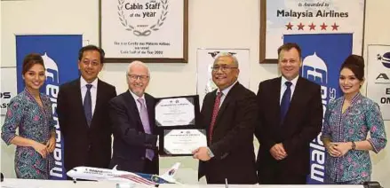  ?? NSTP PIC BY MAHZIR MAT ISA ?? Internatio­nal Air Transport Associatio­n (IATA) training and consulting director Guy Brazeau (third from left) exchanging documents with Malaysia Airlines Academy Bhd chief executive officer (CEO) Captain Kamaruddin Kamilin during a signing ceremony in...