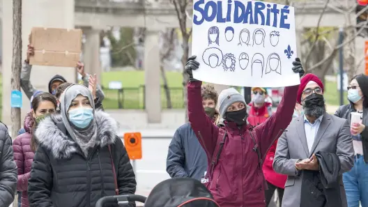  ??  ?? Le jugement rendu hier est un poids de moins pour Zahra Ibrahim, une enseignant­e anglophone qui pourra continuer de porter le voile au travail (à gauche). Elle était parmi les manifestan­ts devant le bureau du premier ministre.