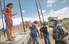  ?? PHOTOS BY LUIS SÁNCHEZ SATURNO/The New Mexican ?? John Villareal of Alcalde, center; Tony Valerio of Española; and Roberto Valdez of Española, who oppose the removal of the Juan de Oñate statue, confront Thantsideh, Sun Bird in the Tewa language, 19, of Ohkay Owingeh, on Monday (June 15) while he dances where the statue used to sit at the Oñate Monument Resource and Visitors Center.