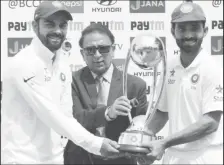  ??  ?? India’s Virat Kohli (L) and Ajinkya Rahane (R) receive the trophy from the former Indian cricket player Sunil Gavaskar after winning the series. REUTERS/Adnan Abidi