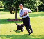  ?? PETE SOUZA/THE WHITE HOUSE 2009 ?? President Barack Obama plays football with Bo on the South Lawn of the White House.