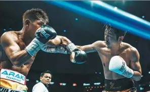  ?? XINHUA ?? Zou Shiming (right) trades punches with Japanese challenger Sho Kimura during their WBO world flyweight championsh­ip bout in Shanghai on Friday night. Kimura won by TKO in 11 rounds.