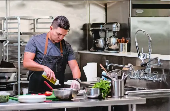  ?? FOOD NETWORK ?? Hot Rod Café Chef Carlos Paucar seasons tomatoes for the garnish to his final dish in the Creativity Challenge on Chef Bootcamp.