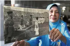  ?? — Bernama ?? Then and now: Rusnah holding up a picture of herself releasing
pigeons at Stadium Merdeka in September 1963.