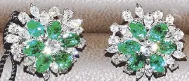  ??  ?? 18K white gold earrings with white round diamonds, white marquise cut diamonds and emeralds