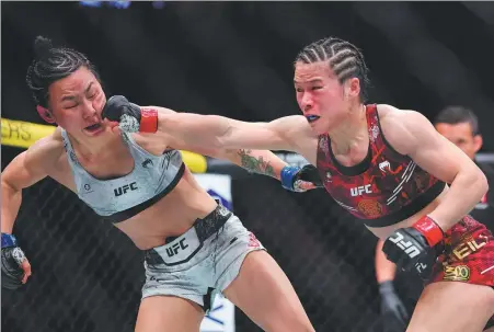  ?? GETTY IMAGES VIA AFP ?? Zhang Weili lands a punch to the face of Yan Xiaonan during their historic all-China strawweigh­t title fight in the co-main event of UFC300 at the T-Mobile Arena in Las Vegas, Nevada, on Saturday.