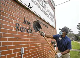  ??  ?? Jimmie Fair Sr., hospital maintenanc­e, removes signage fromaround the building as Southwest Georgia Regional Medical Center finishes its final day of operations Thursday. Some employees will remain for a short time, helping wrap things up, including COVID- 19 testing results fromtests that occurred thisweek.