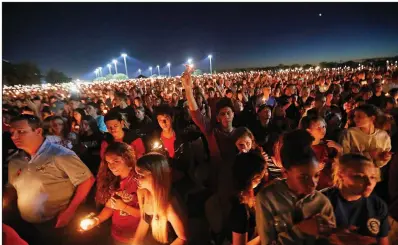  ?? AP/GERALD HERBERT ?? Mourners hold a candleligh­t vigil Thursday night at Marjory Stoneman Douglas High School in Parkland, Fla.