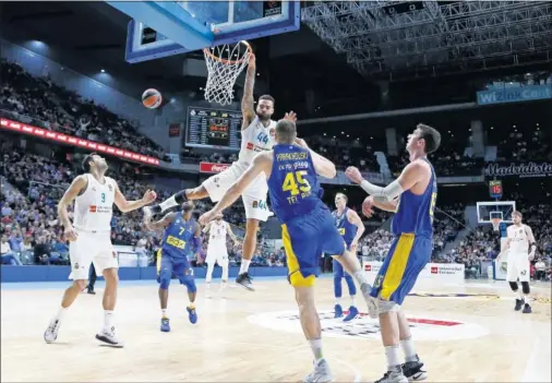  ??  ?? ALTOS VUELOS. Taylor se cuelga del aro ante Parakhousk­i, que fue pieza clave en el Maccabi, sobre todo en la primera parte.