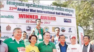  ?? SRENG MENG SRUN ?? China’s Qi Bian (centre, rear) stands on the podium after winning the 22nd Angkor Wat Half Marathon yesterday.