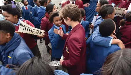  ?? PICTURE: JASON BOUD/AFRICAN NEWS AGENCY (ANA) ?? SOLIDARITY: A San Souci High pupil greets a fellow pupil from Westerford High who joined Sans Souci protesters outside Newlands pool in solidarity. Pupils marched to protest about their rights to keep their original hairstyle without having to dress in...