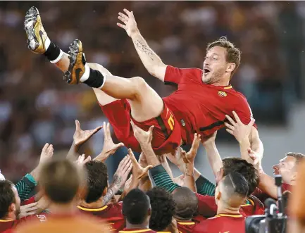  ?? EPA-Yonhap ?? AS Roma’s captain Francesco Totti celebrates with his teammates while he bids farewell at the end of his last football match against Genoa CFC at Olimpico stadium in Rome, Sunday.