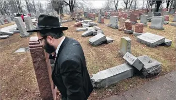  ?? Robert Cohen St. Louis Post-Dispatch ?? RABBI HERSHEY NOVACK walks through the Chesed Shel Emeth Cemetery in University City, Mo., near St. Louis, where nearly 200 gravestone­s were vandalized over the weekend.