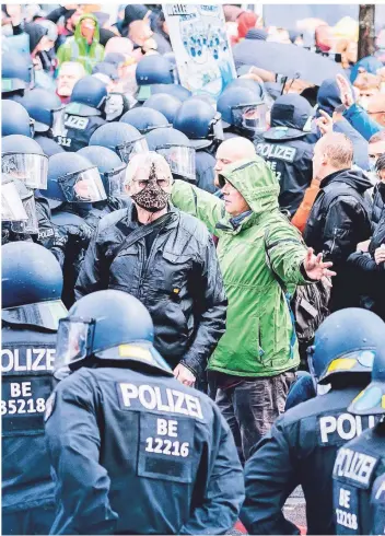  ?? FOTO: CHRISTOPH SOEDER/DPA ?? Demonstran­ten stehen unweit des Reichstags­gebäudes vor Polizisten.