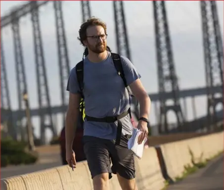  ?? AARON LYNETT FOR THE TORONTO STAR ?? On the first day of the trek, Alex Ballingall walks through Niagara Falls, passing the glitz and flash to head south along the Niagara River.