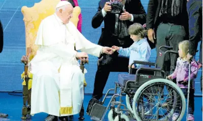  ?? AP ?? Pope Francis presents sweet treats to children during an annual gathering of pro-family organisati­ons at the Auditorium della Conciliazi­one, in Rome yesterday.