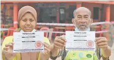  ??  ?? Voters from Chini state constituen­cy showing their voter’s card. - Bernama photo