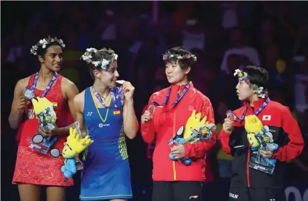  ?? — AFP ?? (L-R) Second-placed PV Sindhu of India, champion Carolina Marin of Spain, third-placed He Bingjiao of China and Akane Yamaguchi of Japan chat on the podium for the women’s singles event during the badminton World Championsh­ips in Nanjing, Jiangsu province.