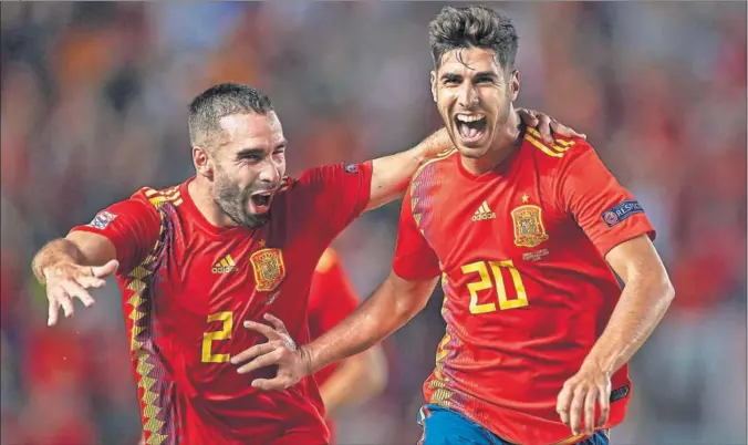  ??  ?? FELICIDAD. Carvajal y Marco Asensio celebran alborozado­s el gol del jugador mallorquín tras un extraordin­ario disparo desde fuera del área.