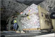  ?? THE ASSOCIATED PRESS ?? Personnel unload emergency aid supplies at Tonga’s Fua’amotu Internatio­nal Airport, near Nuku’alofa, Thursday.