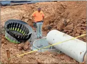  ?? PHOTOS BY SPENCER LAHR ?? ABOVE: Carrollton-based J&amp;R Constructi­on employee Derek Daniel looks down at a drainage pipe, which runs underneath Spider Webb Drive, at the site of the new School.