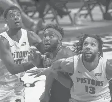  ?? DAVE REGINEK/GETTY ?? The Knicks’ Mitchell Robinson battles for position between the Pistons’Josh Jackson, left, and Jahlil Okafor on Sunday in Detroit.