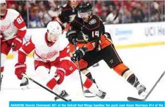  ??  ?? ANAHEIM: Dennis Cholowski #21 of the Detroit Red Wings handles the puck past Adam Henrique #14 of the Anaheim Ducks during the third period of a game at Honda Center n Anaheim, California. — AFP