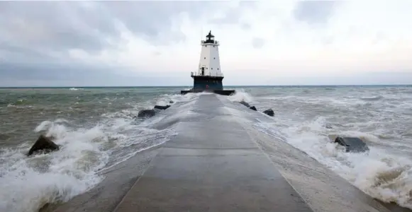  ?? ROBERT RAUSCH PHOTOS/THE NEW YORK TIMES ?? A lighthouse and breakwater sit on Lake Michigan, outside the town of Ludington, Mich.; it was founded in 1845 as a centre for lake trade and remains a home to the only regular cross-lake ferry.