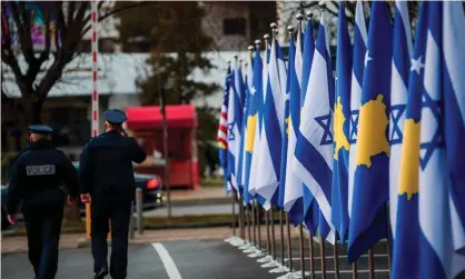  ??  ?? Police officers walk past Kosovan and Israeli flags displayed during a ceremony in Pristina in February after the countries establishe­d diplomatic ties. Photograph: Armend Nimani/AFP/Getty Images