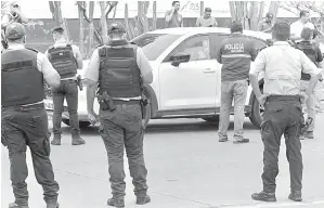  ?? — Gambar AFP ?? PERIKSA: Anggota polis memeriksa kereta pendakwa raya Suarez yang maut ditembak di Guayaquil, Ecuador kelmarin.