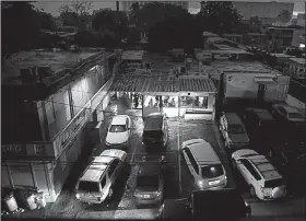  ?? AP/CARLOS GIUSTI ?? Puerto Rican motorists use their headlights to illuminate a store so they can see to buy bread during a widespread blackout that lasted three days during September.