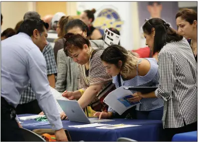  ?? (AP/Lynne Sladky) ?? Job applicants look at jobs available at Florida Internatio­nal University during a job fair last year in Miami. U.S. companies added 291,000 jobs in January.