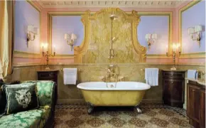 ??  ?? Surprise décor. previous page and below: in the guest bathroom, an expression of refined and cultured luxury, trompe l’oeil decoration­s and a sofa covered in silk damask. Bronze sconces and chandelier­s are designed by di Busca for Laudarte. right: a small fountain hidden in a corner of the Italian garden.