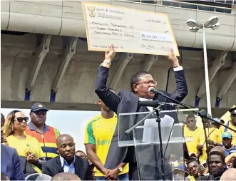  ??  ?? As a token of appreciati­on, the Minister of Sports and Recreation of South Africa presents R700 000 to Sundowns players to share among themselves