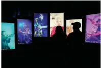  ?? (AP Photo/Mark Humphrey) ?? Visitors watch an exhibit at the National Museum of African American Music in Nashville, Tenn.