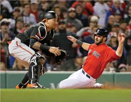  ?? STUART CAHILL / BOSTON HERALD ?? WINNING PATH: Mitch Moreland slides past Baltimore catcher Jesus Sucre during an April game at Fenway. With six games remaining against the Orioles beginning tonight, the Sox could take advantage of the schedule.