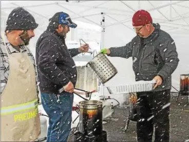  ?? CHRIS BARBER — DIGITAL FIRST MEDIA ?? West Grove firefighte­rs cook the turkey breasts outside as the snow comes down.