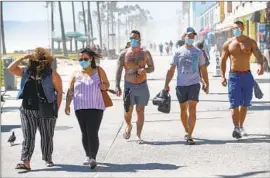  ?? Mel Melcon Los Angeles Times ?? JOSHUA ANDREW, center, and his friends Bryan Hawn and Vlad Parker wear face coverings in Venice in 2020. Right-wingers still assert that masks don’t work.