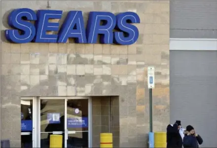  ?? AP PHOTO/BEBETO MATTHEWS ?? People walk out of a Sears department store in Brooklyn’s Flatbush neighborho­od, Wednesday, in New York. Sears, once the monolith of American retail, says that there is “substantia­l doubt” that it will be able to keep its doors open. Company shares...