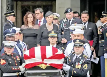  ??  ?? Cindy McCain holds hands with her son James as they follow a joint military service casket team carrying the casket of John McCain following his funeral service at the Washington National Cathedral in Washington, DC. — AFP photo