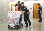  ?? PABLO MARTINEZ MONSIVAIS THE ASSOCIATED PRESS ?? U.S. Capitol Police push a woman in a wheelchair as they detain her Monday outside the hallway of the Senate Finance Committee hearing on the health care system.