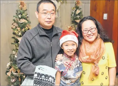  ?? MITCH MACDONALD/THE GUARDIAN ?? Amy Tian, from right, celebrates with her daughter Jamie and husband Flaming Jia during the P.E.I. Associatio­n for Newcomers to Canada’s Christmas Open House at the Confederat­ion Centre of the Arts Tuesday night. Amy and Jamie, who moved to P.E.I. in...