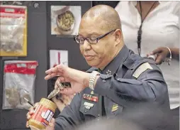  ?? JIM WEBER/THE COMMERCIAL APPEAL ?? Police Director Michael Rallings pulls a smoking pipe from a peanut butter jar during a Memphis City Council committee meeting Tuesday while demonstrat­ing what “small amount” means in real terms regarding marijuana.