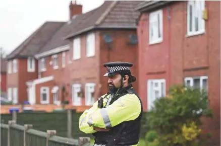  ?? OLI SCARFF AGENCE FRANCE-PRESSE ?? Un officier de police monte la garde devant une résidence en banlieue de Manchester où le suspect Salman Abedi aurait demeuré jusqu’à l’an dernier.