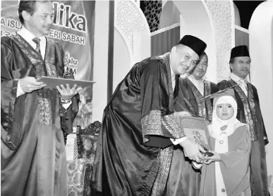  ??  ?? GRADUASI: Ariffin (dua kiri) menyampaik­an sijil kepada salah seorang murid tadika JHEAINS pada majlis itu.