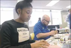  ??  ?? Paris Williams, 13, left, of the Hill District and J. Riesen use kits to create custom game controller­s. Visit postgazett­e.com for a tour of the teen center.