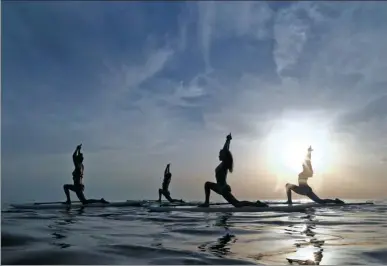  ?? ANTONIO BRONIC / REUTERS ?? People practice standup paddleboar­d yoga, or SUP yoga, on the Adriatic coast in Verudela, Croatia, on Monday.