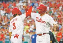  ?? CHRIS SZAGOLA/ASSOCIATED PRESS ?? The Phillies’ Bryce Harper, left, celebrates his two-run home run with Rhys Hoskins during the first inning of Wednesday’s game against the Cubs in Philadelph­ia.
