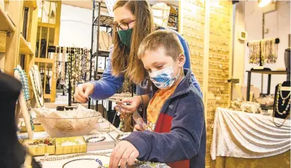  ??  ?? “This year is really important to support places like this one. I want to make sure they stay open,”says Megan Deslatte, of Bethlehem, while doing some holiday shopping with her son Owynn, 5, at The Art Establishm­ent in Fountain Hill on Saturday.